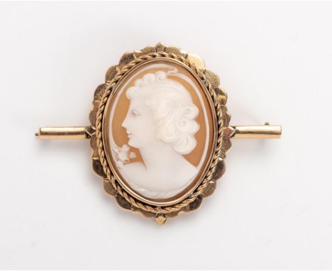 Centred with an oval shell cameo carved with the portrait of a lady, enclosed within a conforming shaped frame with twisted w
