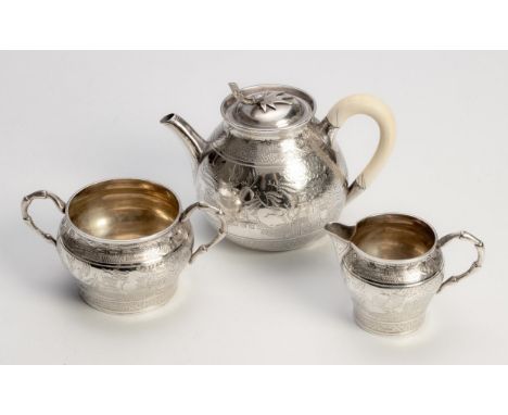 Comprising: a teapot, milk jug and sugar basin, each chased with pergolas and foliage, the teapot with loose cover and bone h