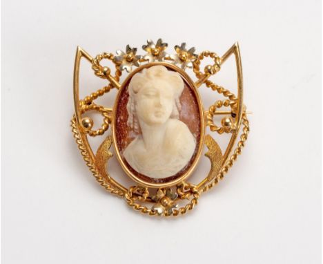 Shield shaped, centred with a shell cameo carved with the portrait of a lady, with twisted wire and flower-head decoration, a