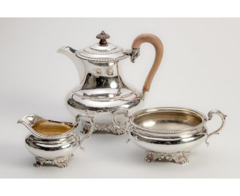 Comprising: a teapot, milk jug and sugar basin, the teapot with hinged cover and wooden finial, gadrooned rim, bulbous body s
