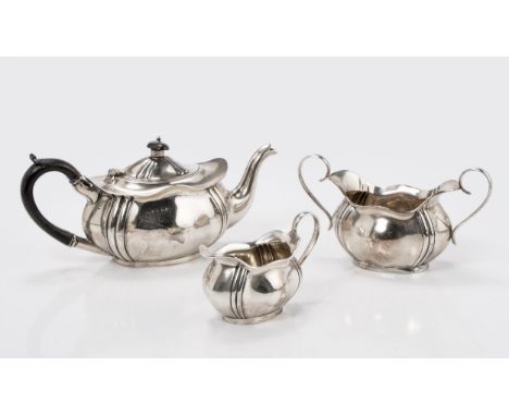Comprising: a teapot, sugar basin and milk jug, the teapot with hinged cover, ebonised finial and leaf-capped handle, each sh