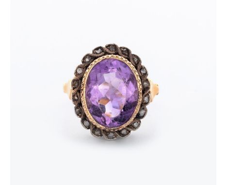 Bezel set to the centre with an oval mixed-cut amethyst weighing approximately 6.19cts, enclosed within a conforming surround