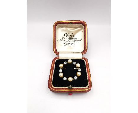 An antique leather boxed French yellow and white metal (tests as 18ct gold) old cut diamond and pearl circular brooch, set wi