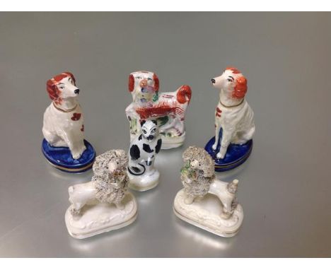 A group of 19th century Staffordshire dog and cat models comprising: a pair of seated spaniels, each on an oval blue and gilt