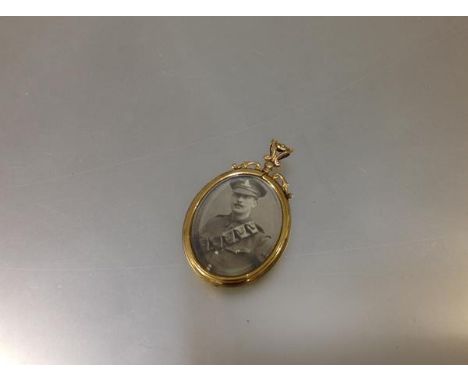 An early 20th century 9ct gold double-sided pendant locket, the oval glazed apertures enclosing portrait photographs of a Wor