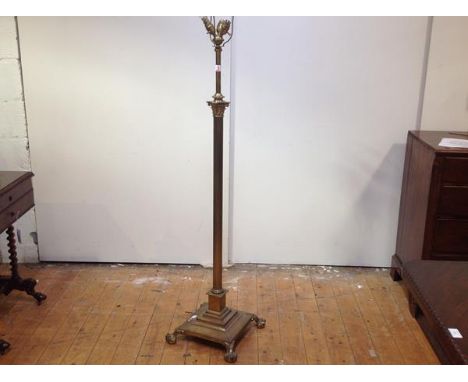 An early 20th century brass Corinthian column adjustable standard lamp, the fluted column raised on a stepped square base sup