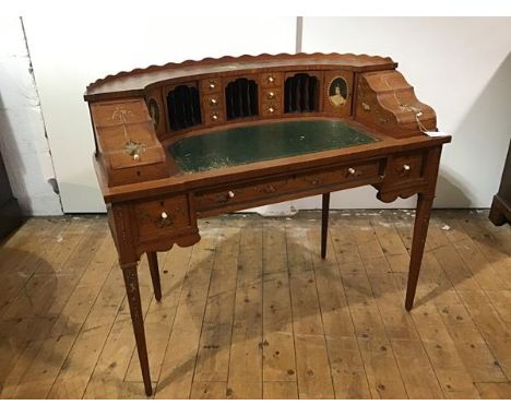 An Edwardian lady's painted satinwood Carlton House desk, the curved superstructure with scroll-carved gallery over an arrang