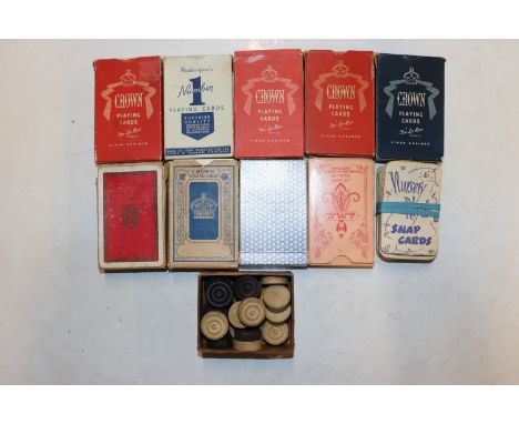 A box of playing cards and draught pieces 