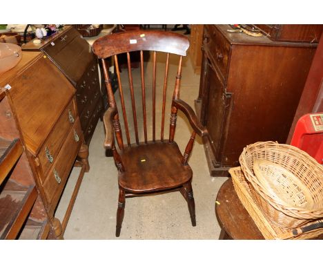 A Victorian elm stick back kitchen elbow chair 