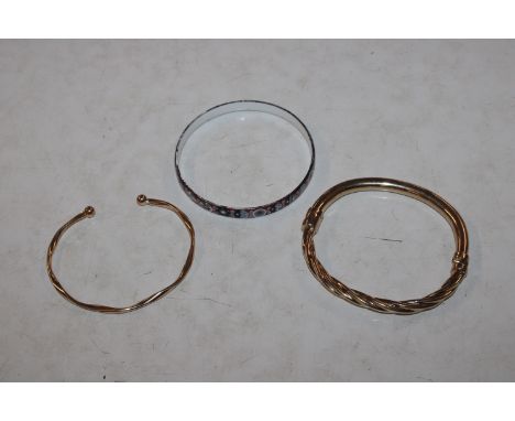 Two yellow metal bangles and an enamel bangle 