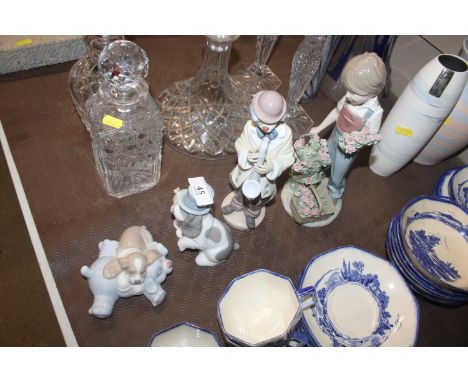 A Lladro porcelain figure of a young girl cutting flowers; another of a clown musician and two Nao dog groups 