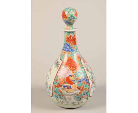 Oriental ceramic bottle shaped decanter and stopper decorated with colourful peonies and birds with two white panels with flo