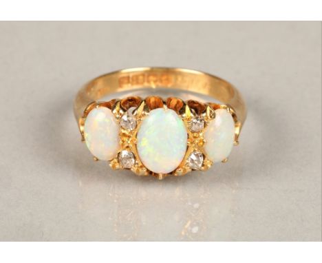 Ladies 18ct yellow gold opal ring, three graduated opals interspersed with four small diamonds set on an 18ct yellow gold sha