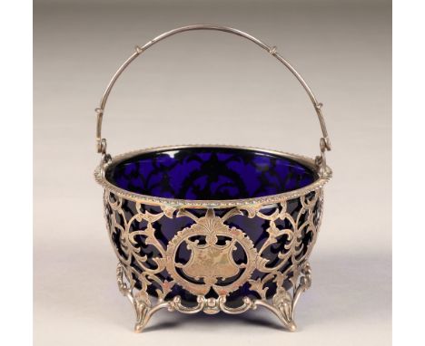 George V silver sugar basin, pierced scroll work, blue glass liner, swing handle raised on four feet, assay marked London 191