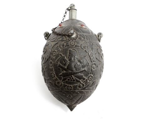 A carved coconut bugbear flask, with pewter fittings and glass eyes, all over relief carved with scrolling leaves, baskets of