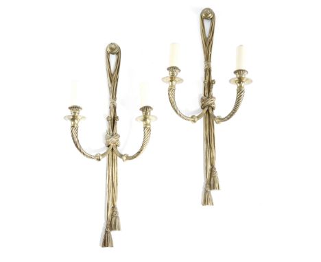 A pair of gilt brass twin-light wall appliques in Louis XVI style, each with a tasselled drape backplate, with spiral ribbed 