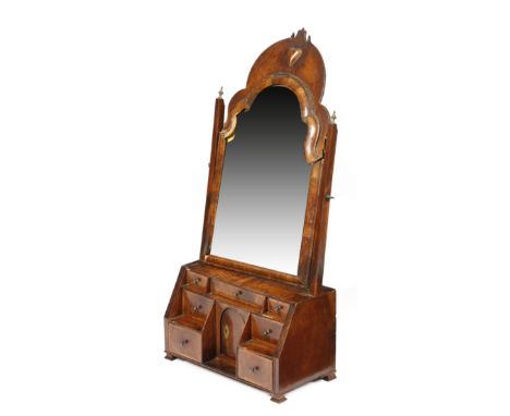 A Queen Anne walnut dressing table mirror, the later bevelled arched plate within a moulded frame and a fret surmount carved 