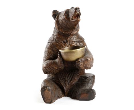 A Black Forest carved wood bear tobacco jar, with glass eyes, with a hinged lid and a brass bowl, late 19th / early 20th cent