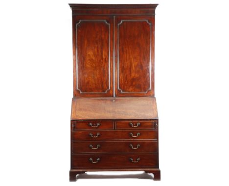 A George III mahogany bureau cabinet, with a dentil cornice above a pair of cupboard doors with outline mouldings, enclosing 