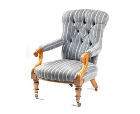 A Victorian walnut open armchair, later upholstered with striped fabric, with a buttoned back, on turned front legs and ceram