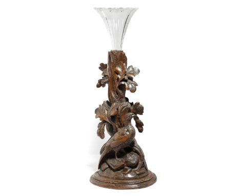 A Black Forest centrepiece, with a detachable fluted vase, with a trunk stem carved with oak leaves and two game birds, late 