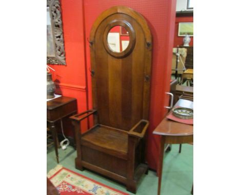 Circa 1930 an oak Dome top hall stand with circular mirror over a hinged box seat flanked by tin umbrella/stick drip trays.  