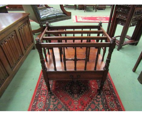 In the manner of Gillows, an Arts &amp; Crafts walnut three division Canterbury with turned supports and spindles having gilt