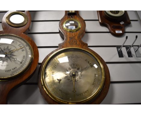 A late Victorian barometer of banjo form with metal face dial and bulls eye mirror