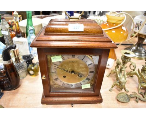 A small bracket mantle clock having brass and similar chased face by Comitti