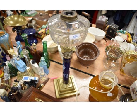 A Victorian oil lamp base having ormolu detailing with porcelain painted shaft and cut glass well
