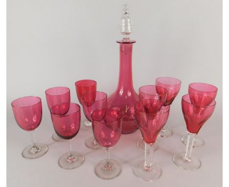 A collection of cranberry tinted glasses, to include a set with tapering bowls and a decanter with a clear glass stopper