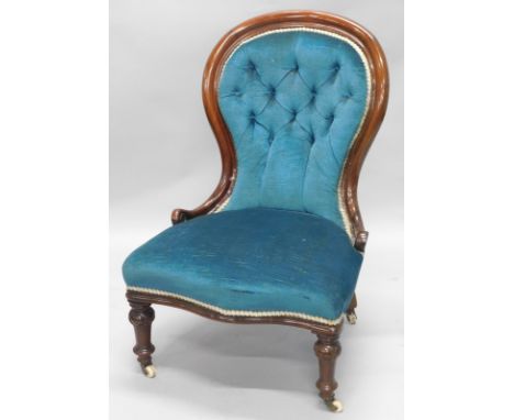 A Victorian mahogany spoon back nursing chair, with a buttoned back padded seat, on turned tapering legs, with ceramic castor