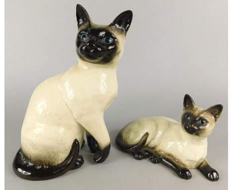 A Royal Doulton standing ceramic model of a Siamese cat, number 1802 and print mark in black to underside, and a Beswick recu