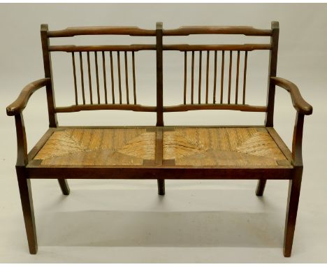 An Edwardian mahogany chair back sofa, with spindle turned back, rush seat, on square tapering legs