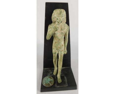 An Egyptian bronze figure of the god Harpocrates, the cast head hollow to the top , 19.5cm high and a Egyptian style roundelP