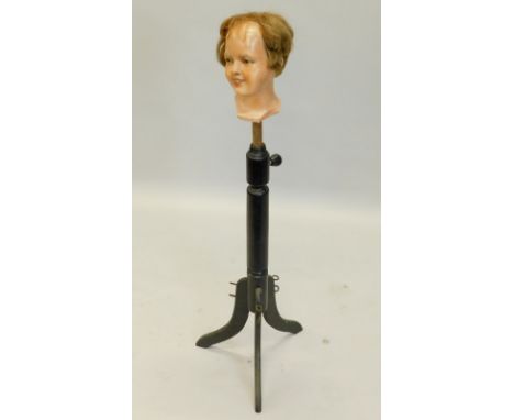 A late 19th and early 20thC ebonised mannequin stand, later inset with a painted dummy's head, possibly to convert into a hat