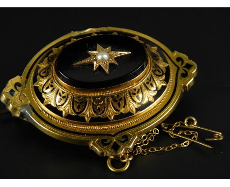 A Victorian mourning brooch, in bloom gold, with black enamel decoration, central black stone and set with seed pearl, with m