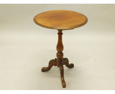 A Victorian mahogany occasional table, the circular top with a moulded edge, above a turned column and carved tripod base, 55