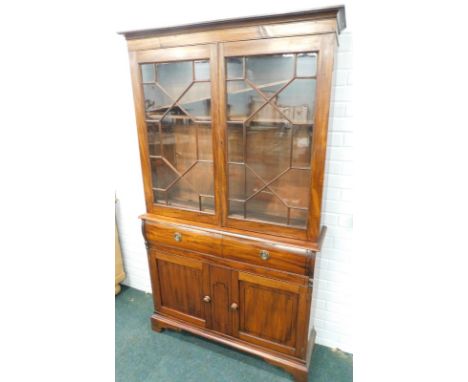 A 19thC mahogany bookcase, the top with two glazed doors enclosing adjustable shelves, the base with two shaped drawers and t