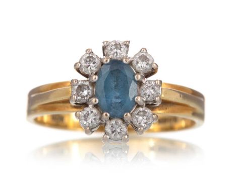 TOPAZ AND DIAMOND RING, set with an oval topaz within a halo of diamonds, in eighteen carat gold, size LQty: 3.5g