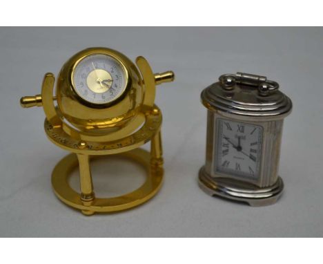 TWO MINIATURE QUARTZ TIMEPIECES, one in the form of a carriage clock, 4.5cm high, the other in a brass globe frame on stand 5