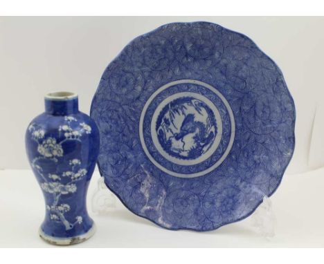 A JAPANESE CERAMIC DISH with blue transfer printed decoration, featuring a dragon at the centre, 27cm diameter, together with