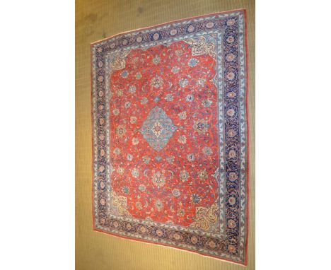 A PERSIAN SAROUGH CARPET, brick red ground stylised overall floral design pale blue and cream, deeply bordered, 330cm x 251cm