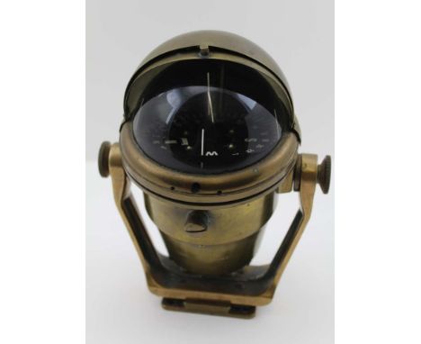 A "SESTREL" MARINE COMPASS in a brass casing with sliding cover, gimbal mounted, black dial inscribed "Sestrel" and "Made in 