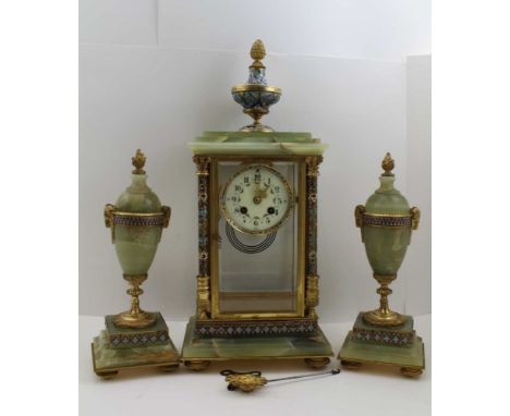 A FRENCH EMPIRE DESIGN ONYX AND CHAMPLEVE ENAMEL GARNITURE CLOCK SET, the clock with bevelled glass panels, on urn mount, a c