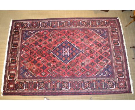 A HAND KNOTTED PERSIAN WOOL JOSHEGHAN FLOOR CARPET, the centre having diamond lozenge and geometric stylised field, with mult