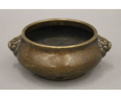 A late 18th/early 19th century Chinese circular bronze censer of squat form with lion head bosses, Xuande seal mark to base. 