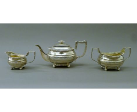 A Georgian three-piece silver tea set. The teapot 30 cm long. 46.1 troy ounces total weight.NOTE This lot is sold with an ivo