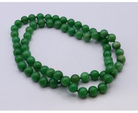 A string of green jade beads.  80 cm long. 