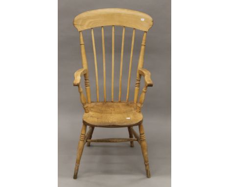 A elm-seated stick back open armchair. 54 cm wide.